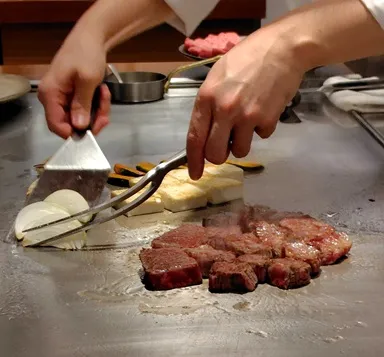 鉄板で焼かれている肉や玉ねぎ、豆腐とかぼちゃ